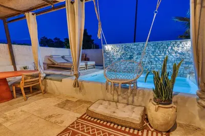 a patio with a chair and a swimming pool at VILLA Isle sur la Sorgue in LʼIsle-sur-la-Sorgue