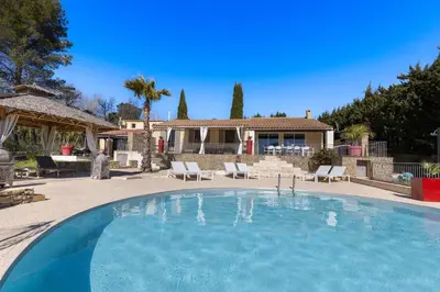a large swimming pool in front of a house at La Villa L'Isle-St-Antoine piscine chauffée in LʼIsle-sur-la-Sorgue