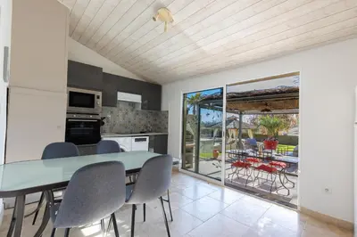 a kitchen and dining room with a table and chairs at La Villa L'Isle-St-Antoine piscine chauffée in LʼIsle-sur-la-Sorgue