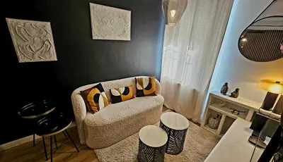 a living room with a couch and some stools at Suite dans le centre historique in Aix-en-Provence