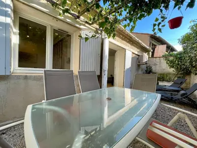 a glass table and chairs on a patio at Chaleureux Appartement RDC 49 m2 avec Jardin in Aix-en-Provence