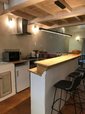 a kitchen with a counter with stools in it at Les goûts et les couleurs in Cucuron