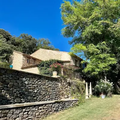 a stone wall in front of a house at Les goûts et les couleurs in Cucuron