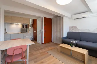a living room with a table and a couch at Studio climatisé plein centre 3eme étage in Aix-en-Provence