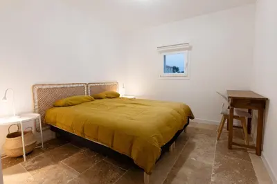 a bedroom with a bed with a yellow blanket at L' Aglandau Au coeur des oliviers en Provence in Pélissanne