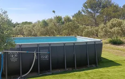 a large swimming pool with a hose around it at L' Aglandau Au coeur des oliviers en Provence in Pélissanne