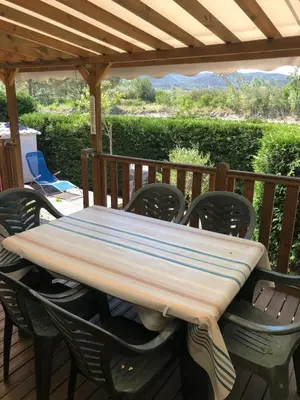a wooden table and chairs on a deck at Domaine des Iscles mobile home clim, jardinet sans vis-à-vis in La Roque-dʼAnthéron
