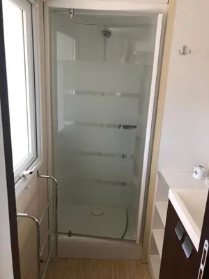 a glass shower in a bathroom with a sink at Domaine des Iscles mobile home clim, jardinet sans vis-à-vis in La Roque-dʼAnthéron
