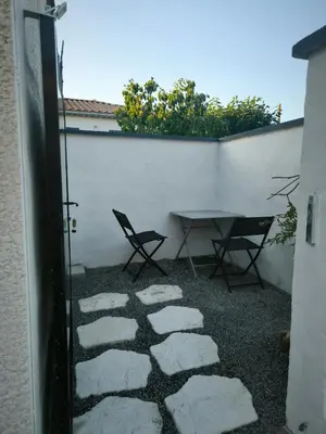 a patio with a table and a chair next to a wall at Logement 2 personnes in Morières-lès-Avignon