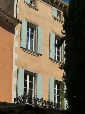 a building with green shuttered windows on it at Atlantes de Saint Saturnin in Saint-Saturnin-les-Apt