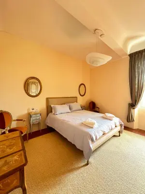 a bedroom with a bed and a table and a mirror at Atlantes de Saint Saturnin in Saint-Saturnin-les-Apt