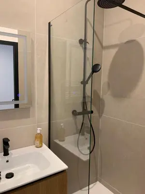 a shower with a glass door next to a sink at Studio au cœur d Aix en Provence in Aix-en-Provence