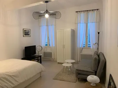 a bedroom with a bed and a chair and a television at Studio au cœur d Aix en Provence in Aix-en-Provence