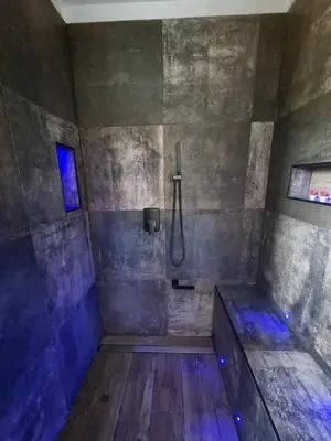 a large bathroom with a shower with blue lights at Maison du Luberon in Maubec