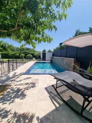 a pergola on a patio with wicker furniture at Maison du Luberon in Maubec