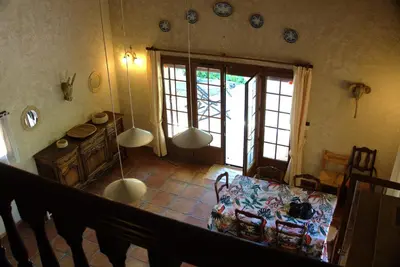 a living room with a table in a room with windows at Villa provençale 4 chambres à Aix en Provence in Aix-en-Provence