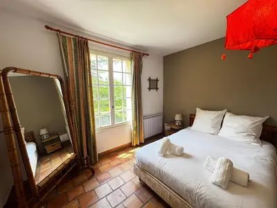 a bedroom with a bed and a large mirror at La Provençale - Piscine - Chambres climatisées in Aubignan