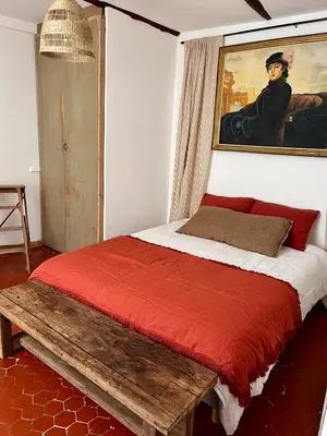 a bedroom with a bed and a painting on the wall at Charmante maison de village dans le Luberon in Beaumont-de-Pertuis