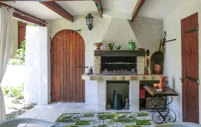 a kitchen with a fireplace and a wooden door at Amazing Home In Vedène in Vedène