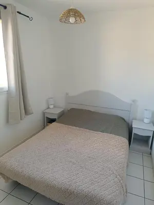 a bedroom with a bed and two night stands at La Cigale d'Avignon in Saint-Saturnin-lès-Avignon