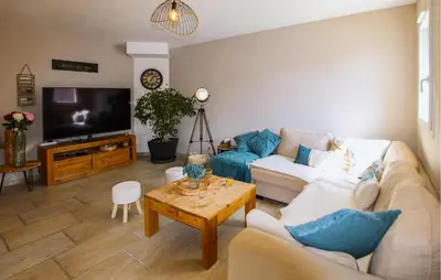 a living room with a couch and a tv at Villa Contemporaine Provençale in Mormoiron
