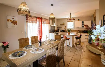 a kitchen and dining room with a wooden table and chairs at Villa Contemporaine Provençale in Mormoiron