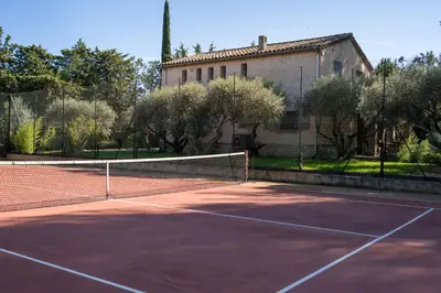 a tennis court in front of a building at Gite Lucie in Carpentras