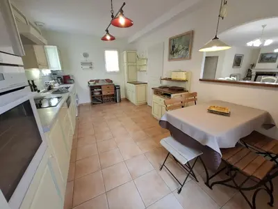 a kitchen with a table and a table and chairs at Villa Nicole avec piscine & jardin privés, parking dans le cœur du Luberon, proche Gordes, Roussillon, Goult, Bonnieux in Oppède