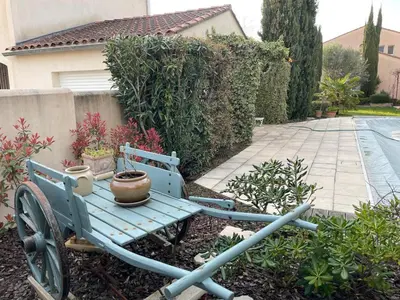 a blue cart with a pot on it in a garden at Villa Nicole avec piscine & jardin privés, parking dans le cœur du Luberon, proche Gordes, Roussillon, Goult, Bonnieux in Oppède