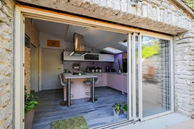 an open kitchen with a table and a counter at Le MAS DES VERGIERS in Murs