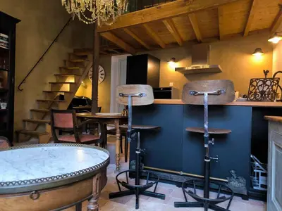 a bar with stools and a counter with a table at Appartement Superbe 2 personnes Coeur de ville l'Isle sur Sorgue in LʼIsle-sur-la-Sorgue