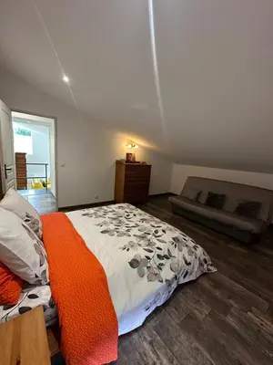 a bedroom with a large bed with an orange blanket at Gite le pèlerin in Sault-de-Vaucluse