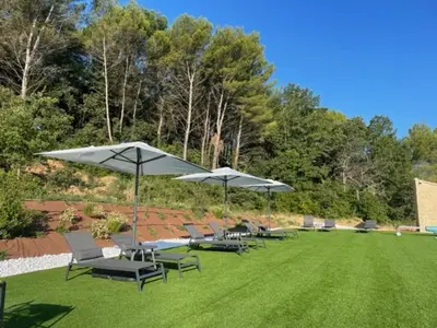 a group of chairs and umbrellas on a lawn at Villa Noyau & Pépin in Rognes