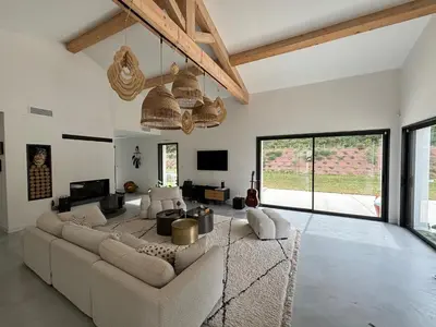 a living room with a large couch and a tv at Villa Noyau & Pépin in Rognes