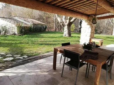 a wooden table and chairs on a patio at country house in Provence in Pierrevert