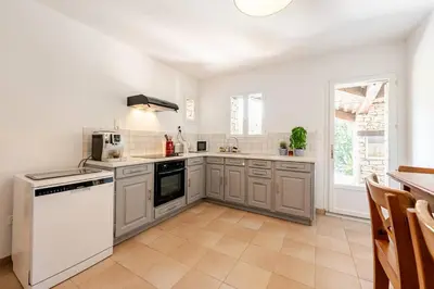 a kitchen with white appliances and a large window at Gordes Villa avec piscine chauffée et privée , jacuzzi et pétanque calme in Gordes