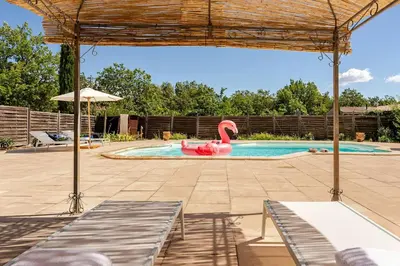 a swimming pool with a red swan in the middle at Gordes Villa avec piscine chauffée et privée , jacuzzi et pétanque calme in Gordes