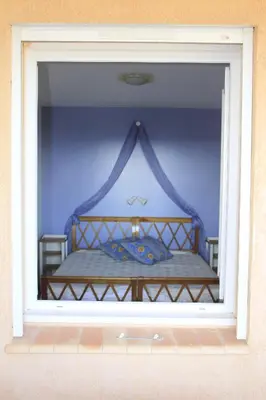 a glass window of a bedroom with a bed at Appartement les Balcons d'Azur in Vernègues