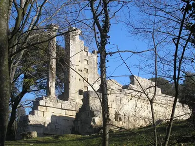an old stone building on a hill with trees at Appartement les Balcons d'Azur in Vernègues