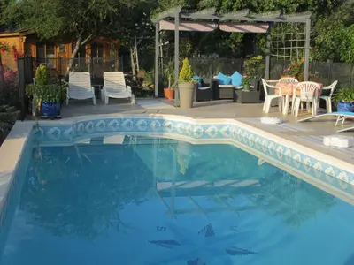 a swimming pool with chairs and a table and a tent at Appartement les Balcons d'Azur in Vernègues