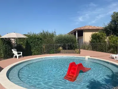 a pool with two red chairs in the water at Maison aux Demeures du Ventoux in Aubignan