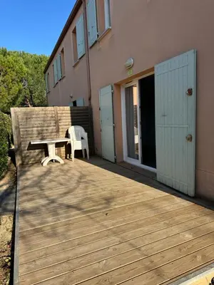 a wooden deck with a table and a chair on it at Maison aux Demeures du Ventoux in Aubignan