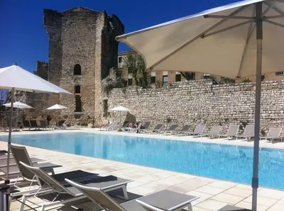 a pool with chairs and umbrellas next to a building at Apparemment hypercentre Aix-en-Provence in Aix-en-Provence