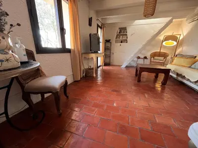 a living room with a couch and a staircase at Aix-en-Provence, Bastidon provençal plein cœur de la forêt avec vue unique in Le Tholonet