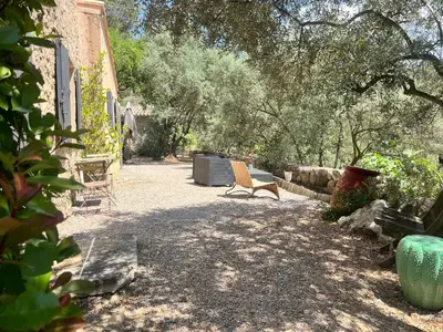 a building on a hill with two chairs and a table at Aix-en-Provence, Bastidon provençal plein cœur de la forêt avec vue unique in Le Tholonet