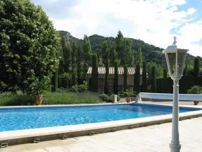 a swimming pool in front of a house with a lamp at Maison en PROVENCE in Robion en Luberon