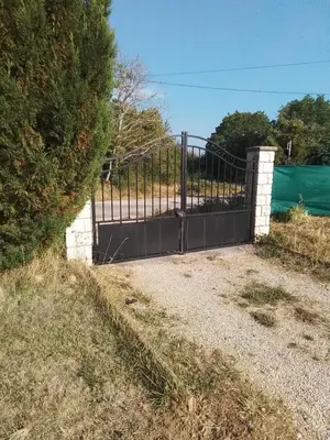 a black gate in a field with a fence at Ventoux beautiful quiet house in Saint-Christol