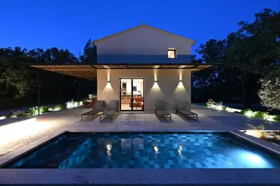 a villa with a swimming pool at night at Le Mazet de la Truffière in Gordes