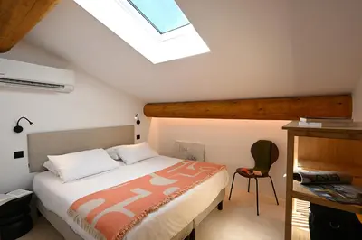 a bedroom with a bed and a skylight at Le Mazet de la Truffière in Gordes