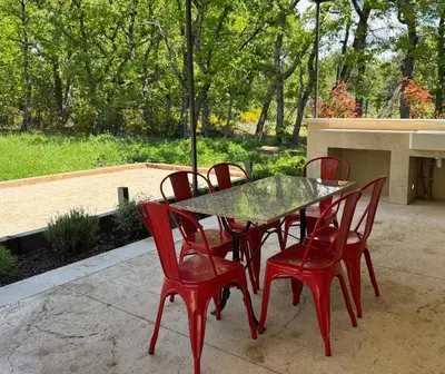 a table and four red chairs sitting around it at Le Mazet de la Truffière in Gordes